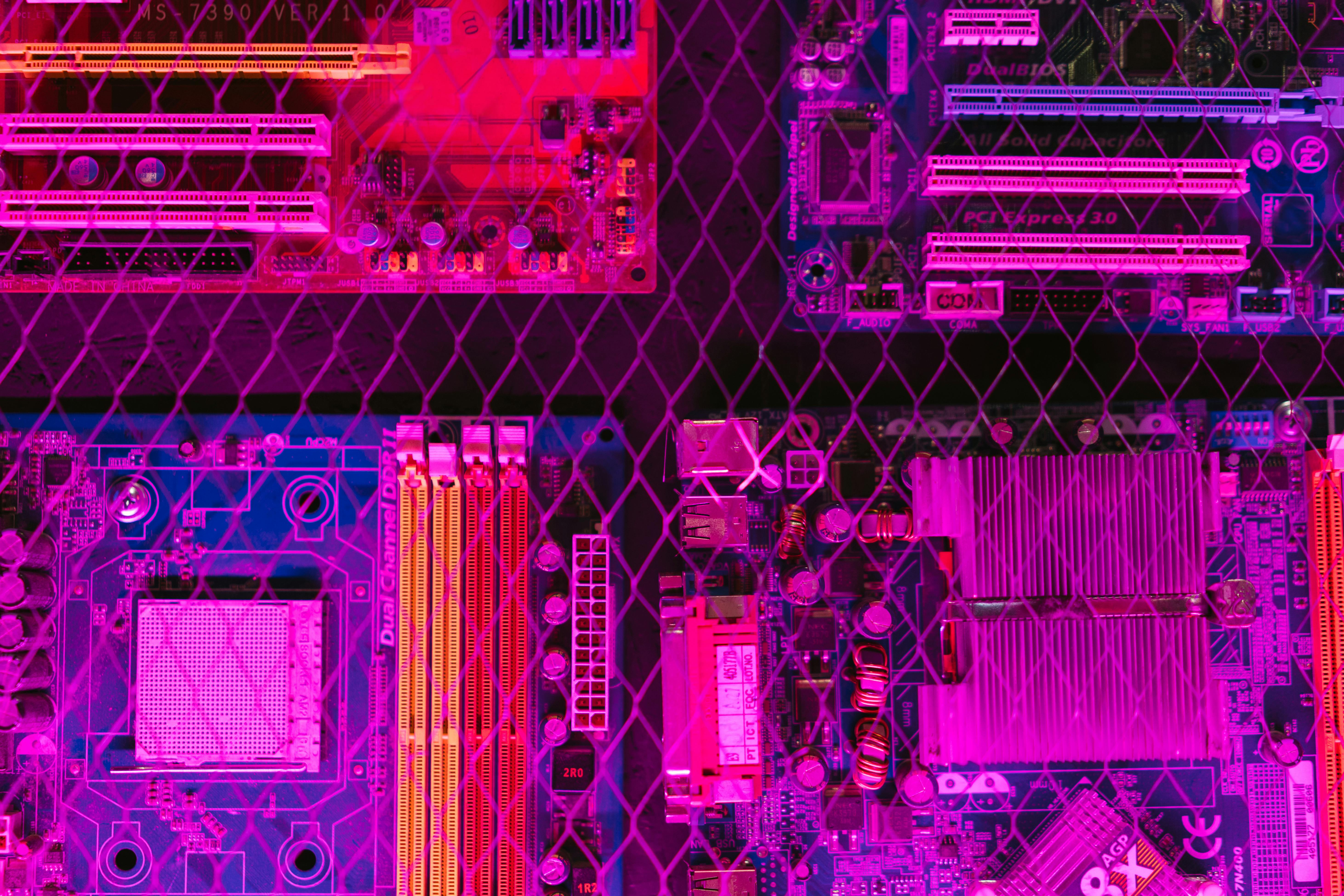 Circuit board behind wire mesh with neon lighting (technology abstract)
